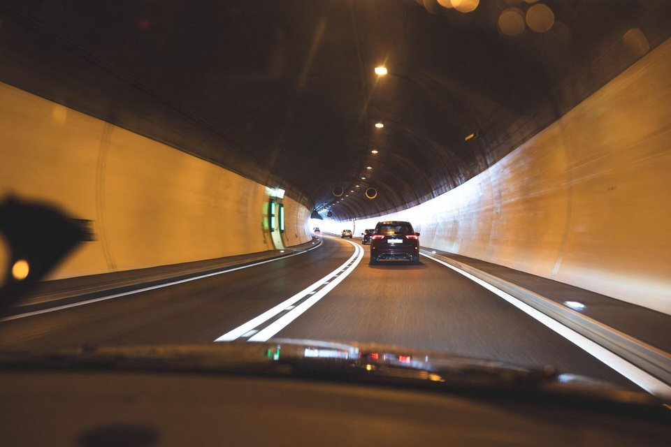 3EJ2249 Gotthard Tunnel, Switzerland, May 18, 2026. A forward-facing view from inside a car driving through a well-lit road tunnel, showing cars ahead in the